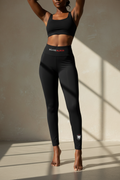 Black leggings with 'WEAREALBOS' text on a white background
